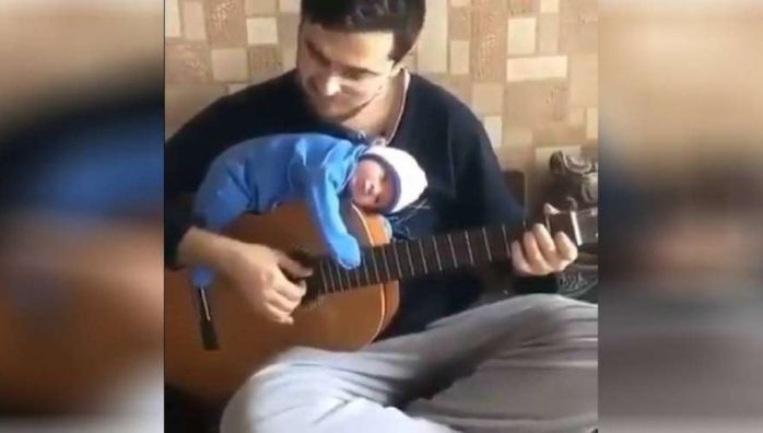 Father plays guitar with his newborn video goes viral.